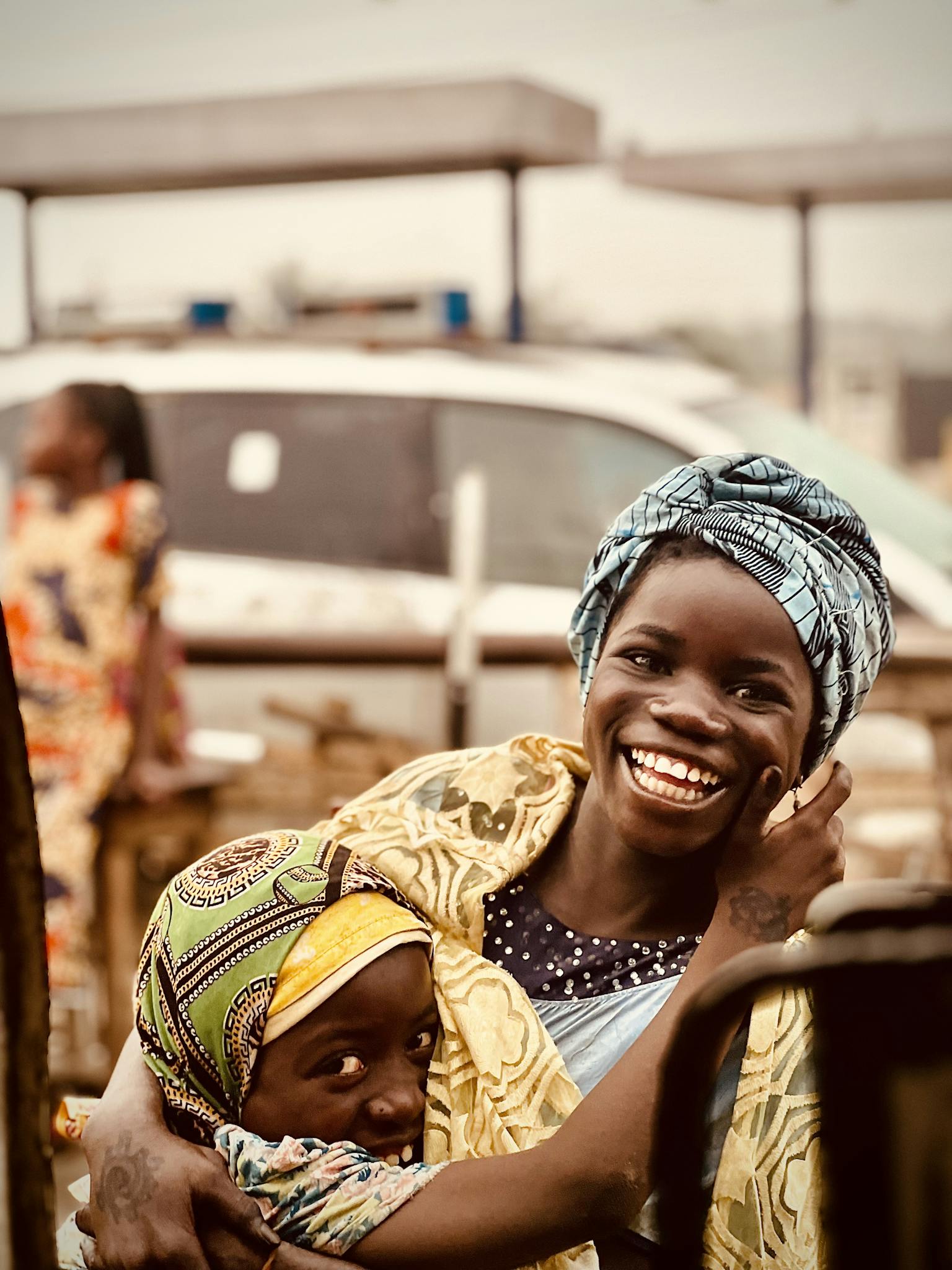 A mother and child sharing a joyful moment outdoors in Africa.