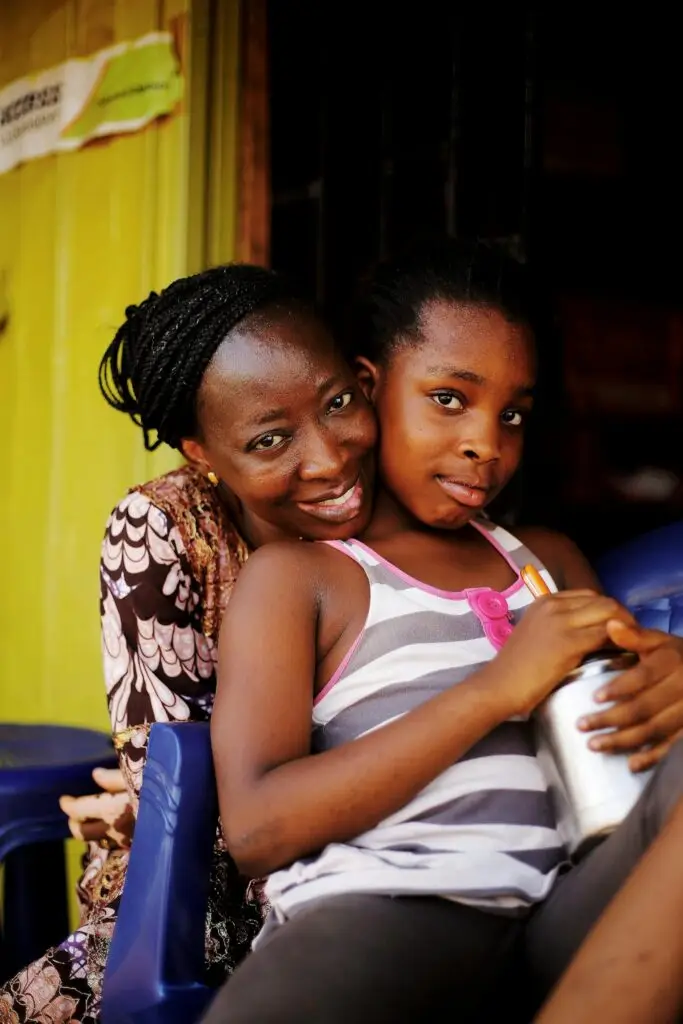 A warm portrait of a mother embracing her daughter in Abuja, Nigeria, radiating love and connection.