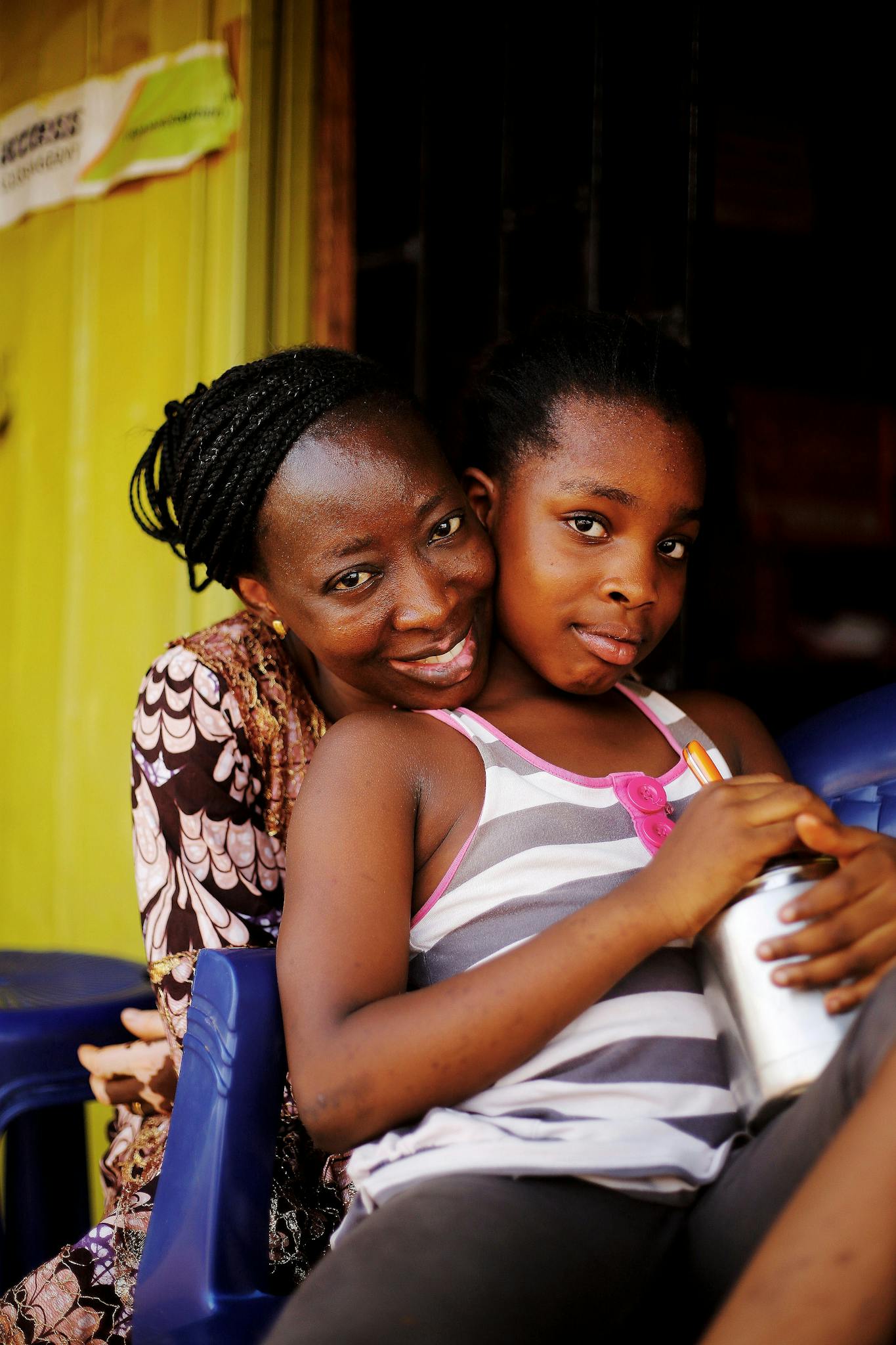 A warm portrait of a mother embracing her daughter in Abuja, Nigeria, radiating love and connection.